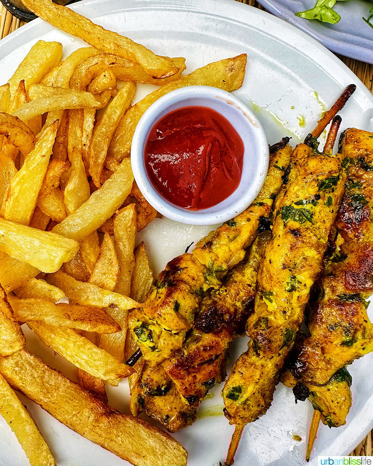 Moroccan chicken skewers with fries.