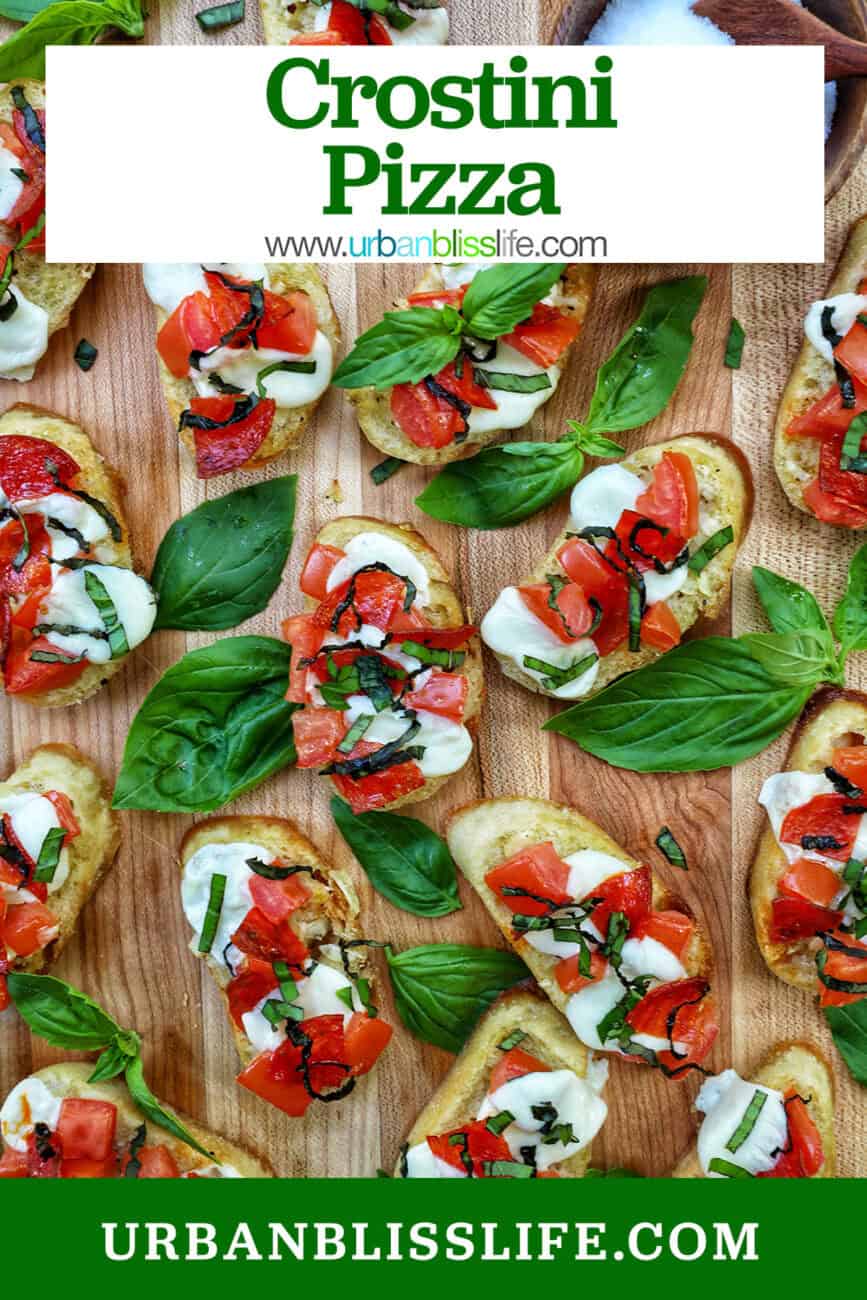 lots of crostini pizzas on a wooden board with title text overlay.