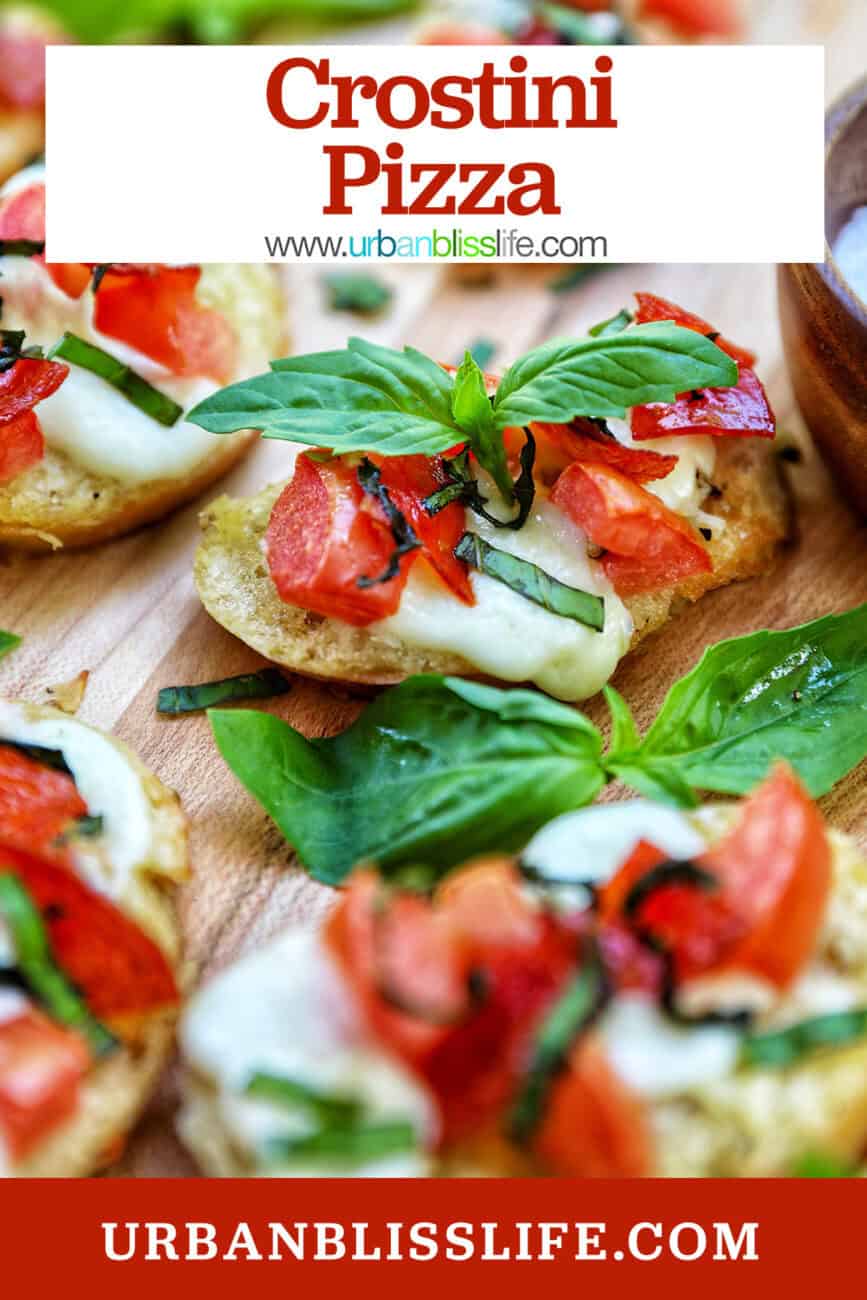 lots of crostini pizzas on a wooden board with title text overlay.