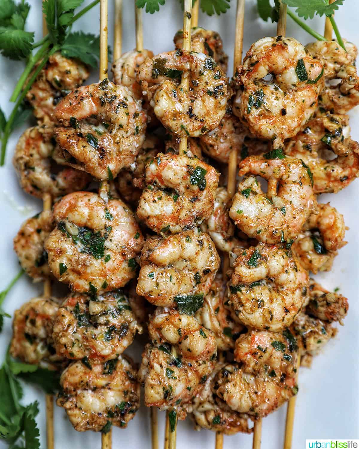 prawn BBQ skewers stacked on a plate.