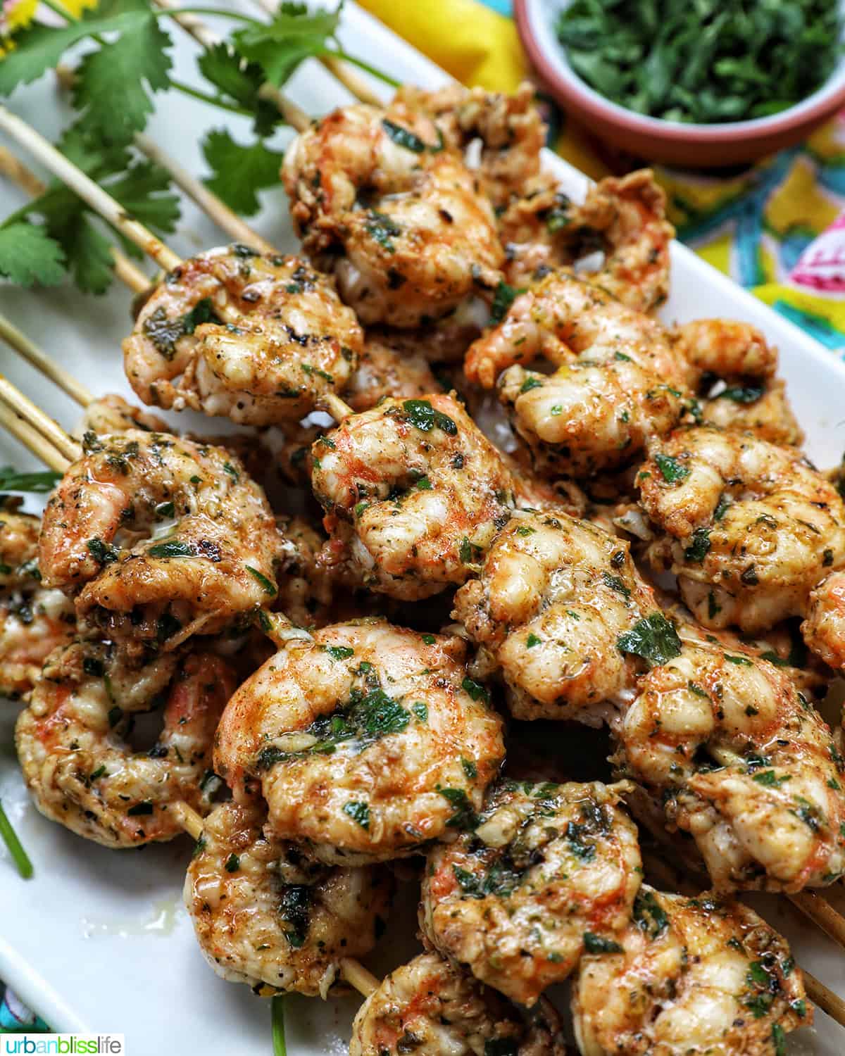 prawn BBQ skewers stacked on a plate.