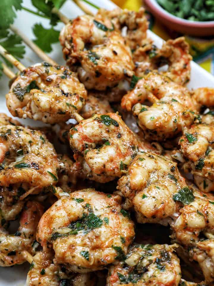 prawn BBQ skewers stacked on a plate.