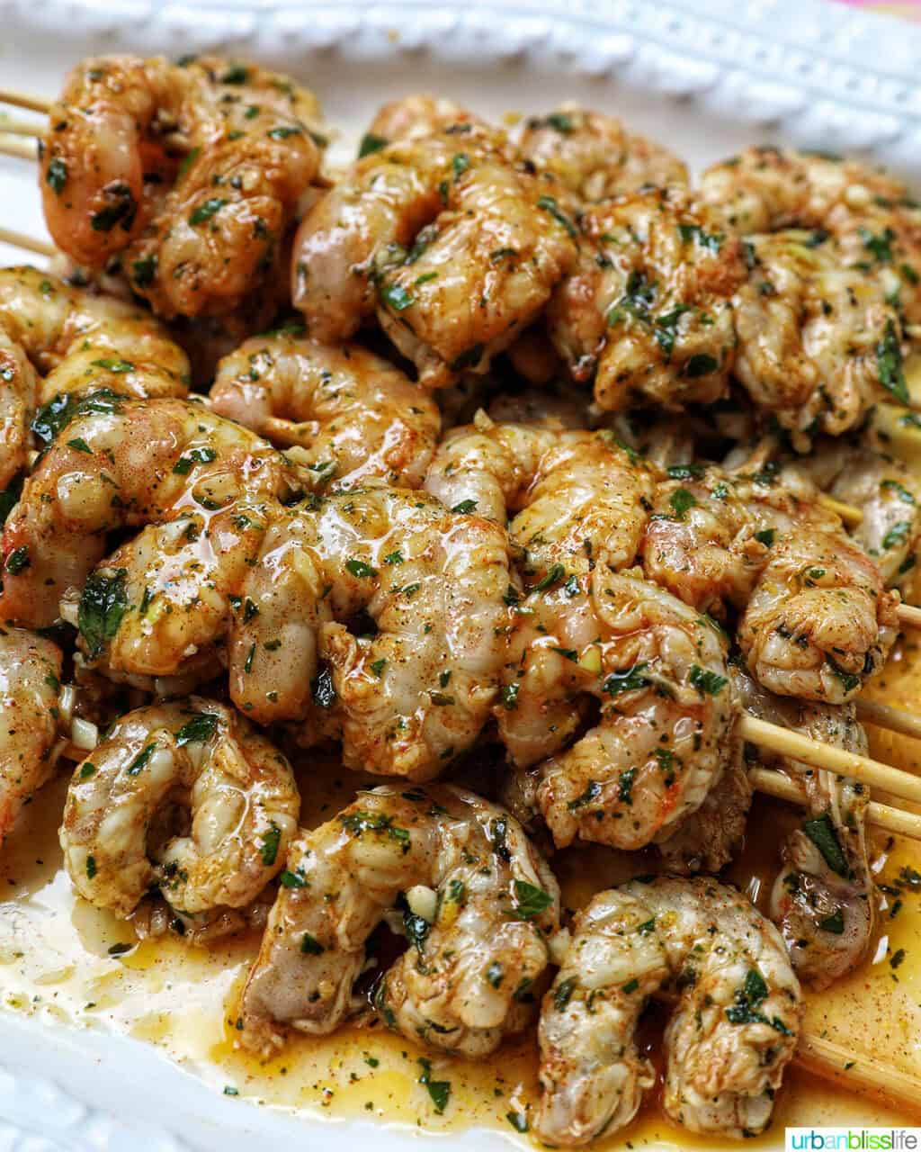 prawn BBQ skewers stacked on a plate.