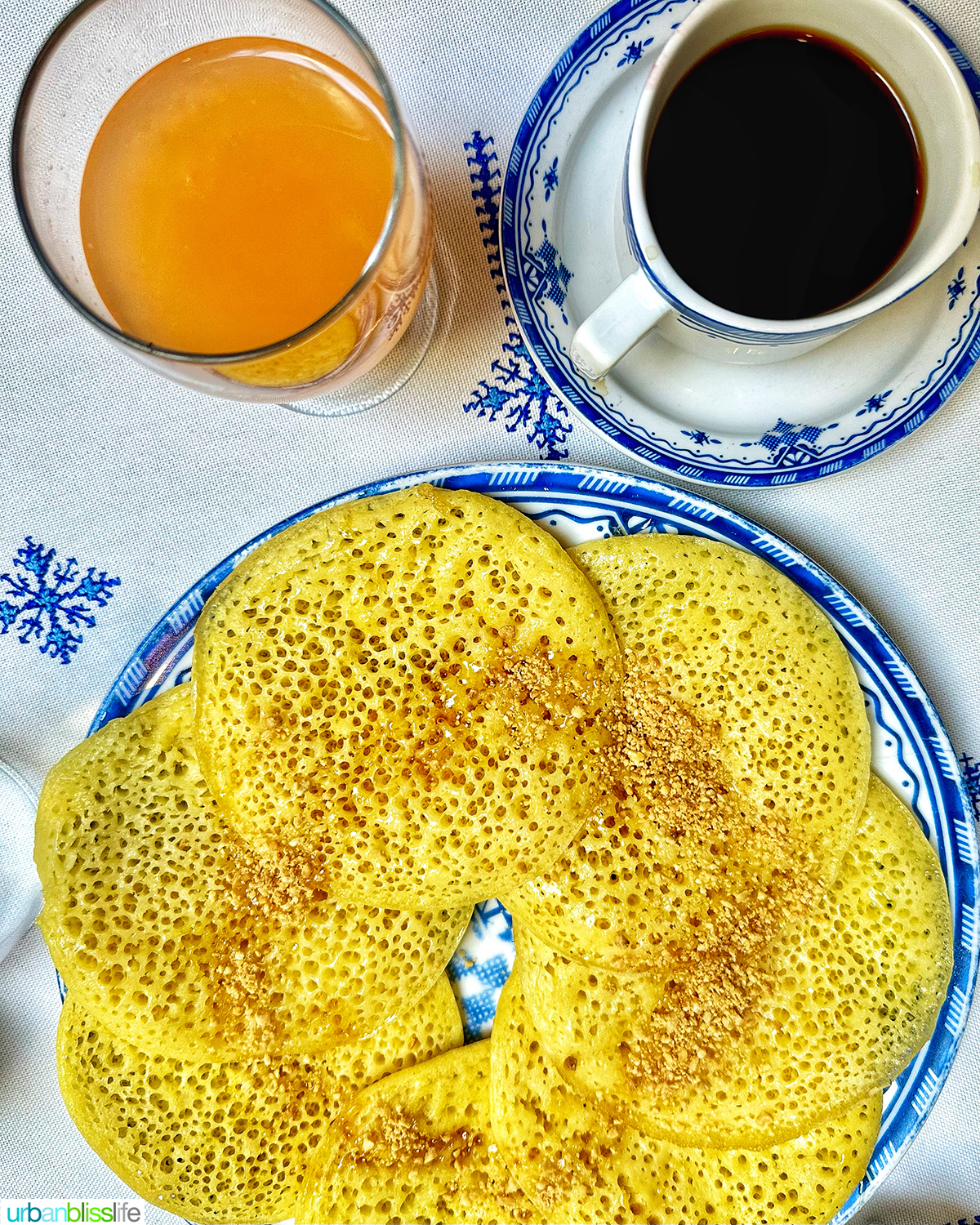 Moroccan pancakes - Baghrir - with glasses of juice and coffee.