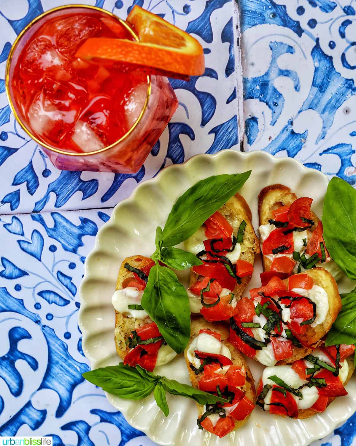 strawberry spritz with plate of crostini pizza.
