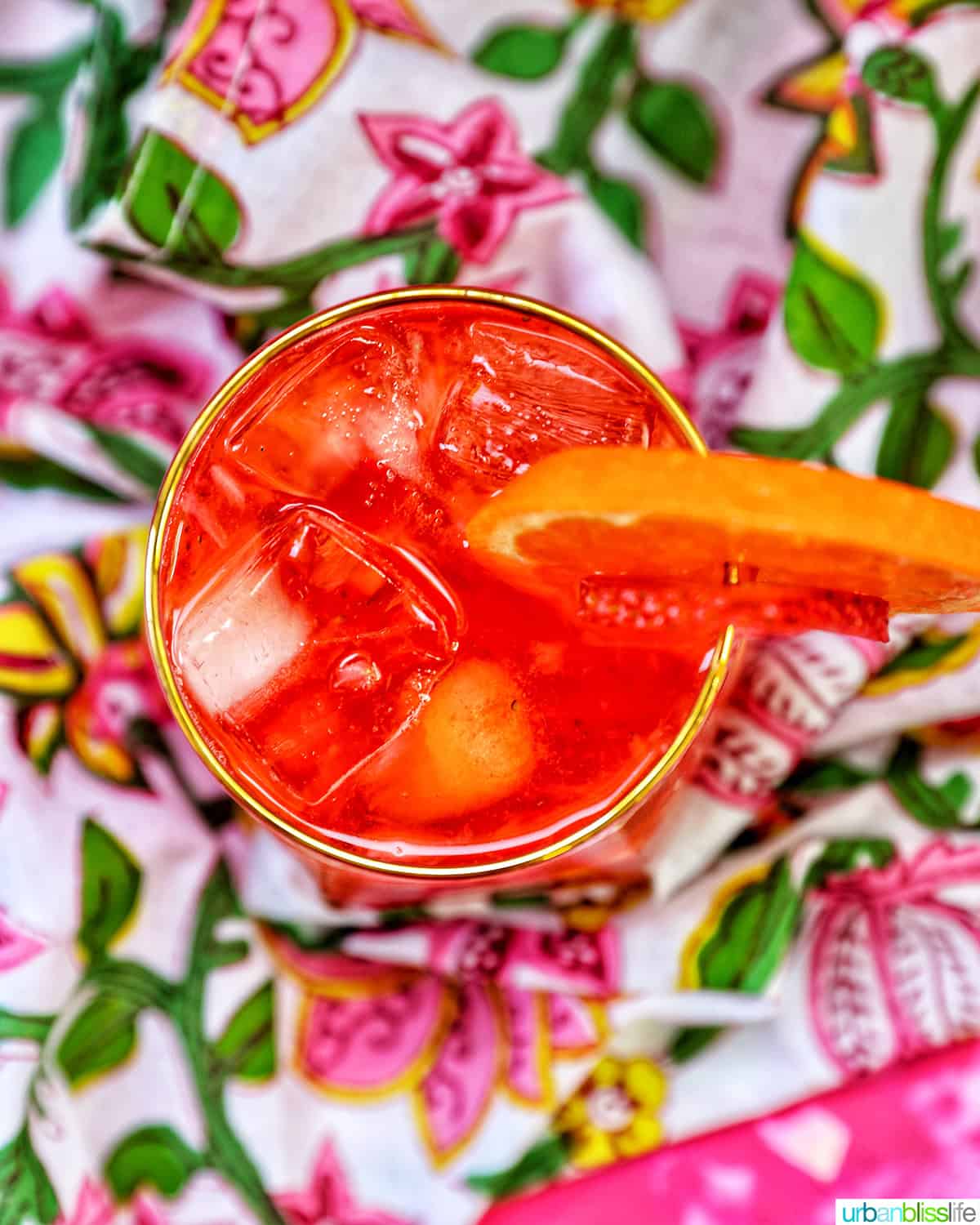strawberry spritz with orange and strawberry garnish.