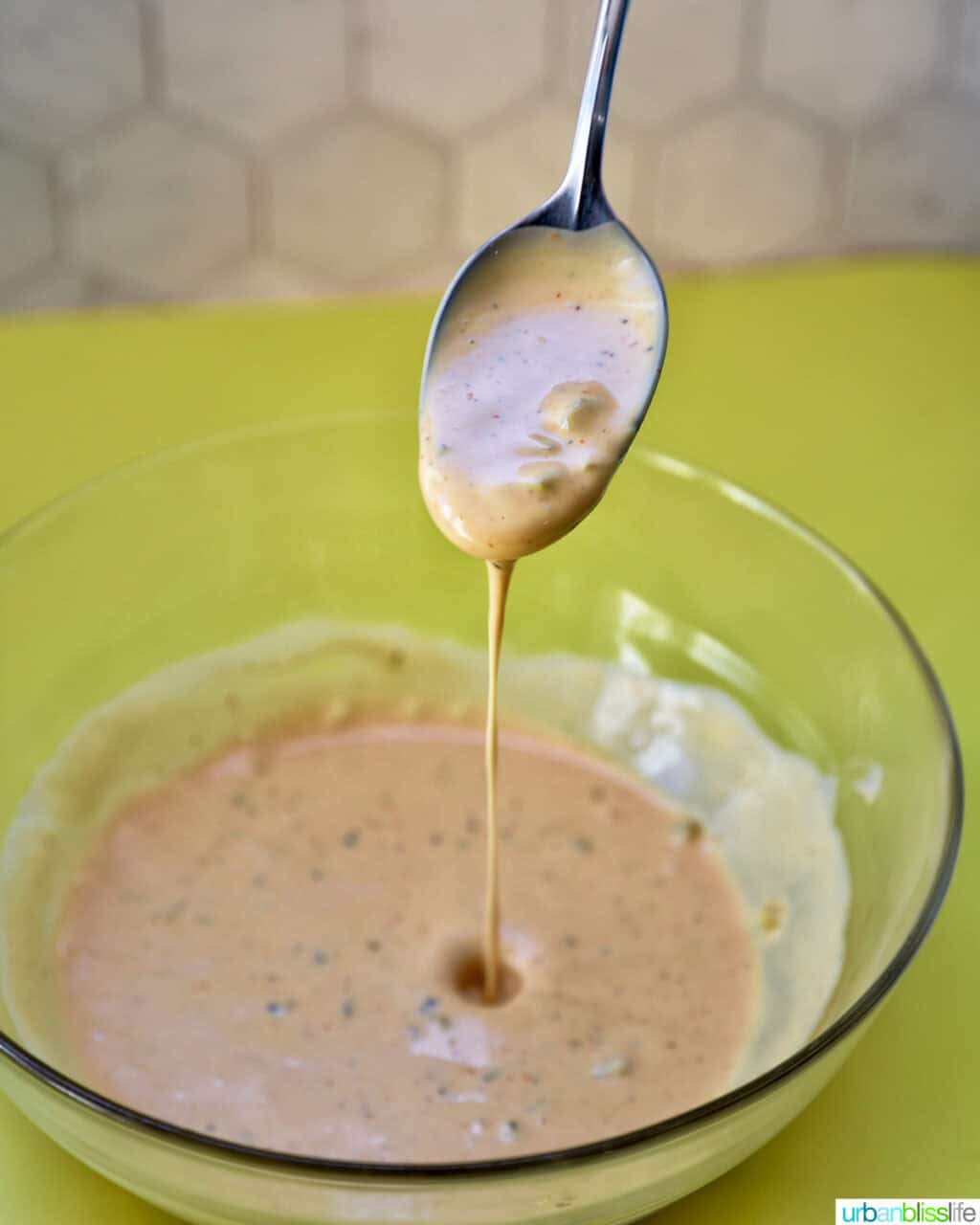 spoon dripping big mac sauce over a bowl of sauce.