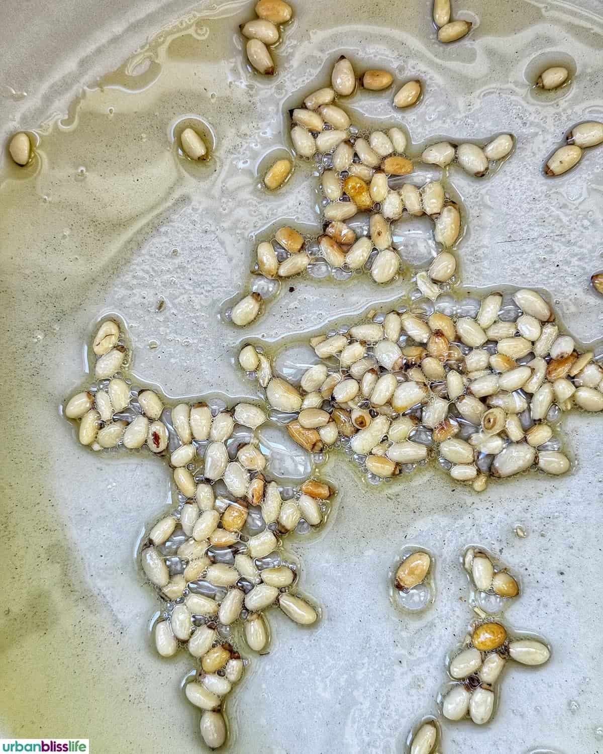 pine nuts roasting in a skillet.