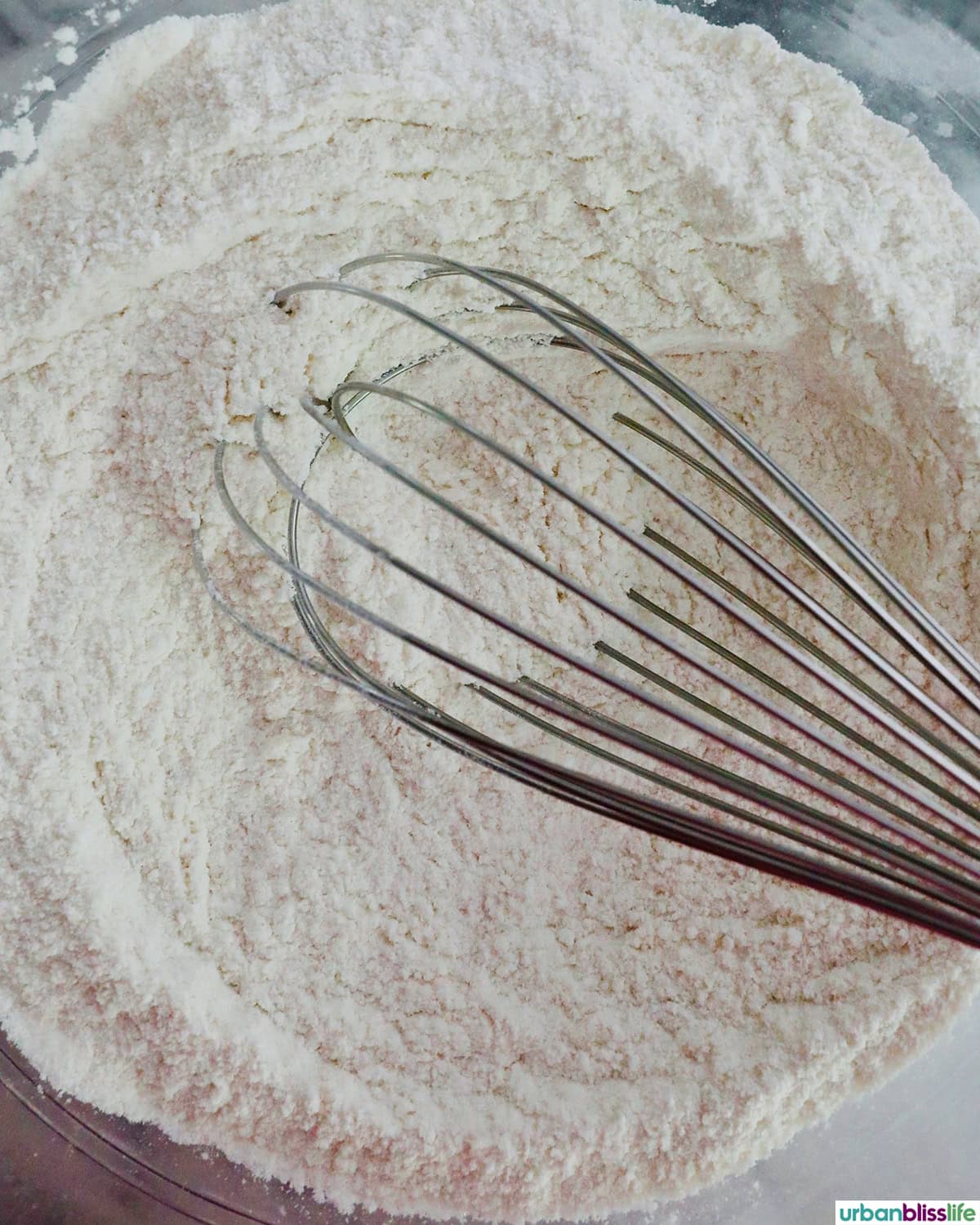 bowl of dry ingredients for baking in a bowl with a whisk.