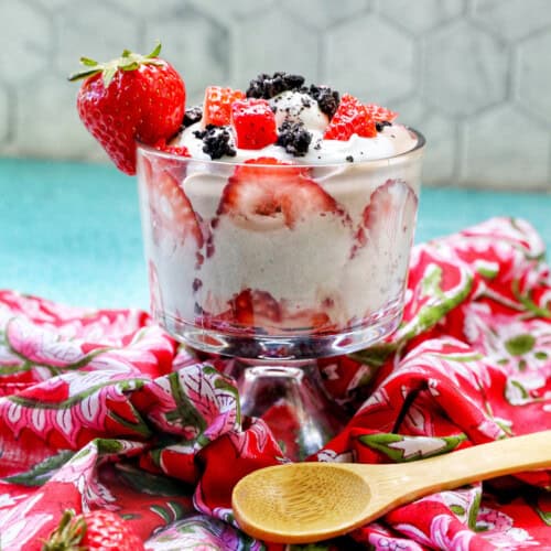 chocolate parfait with fresh berries on a red napkin with wooden spoon.