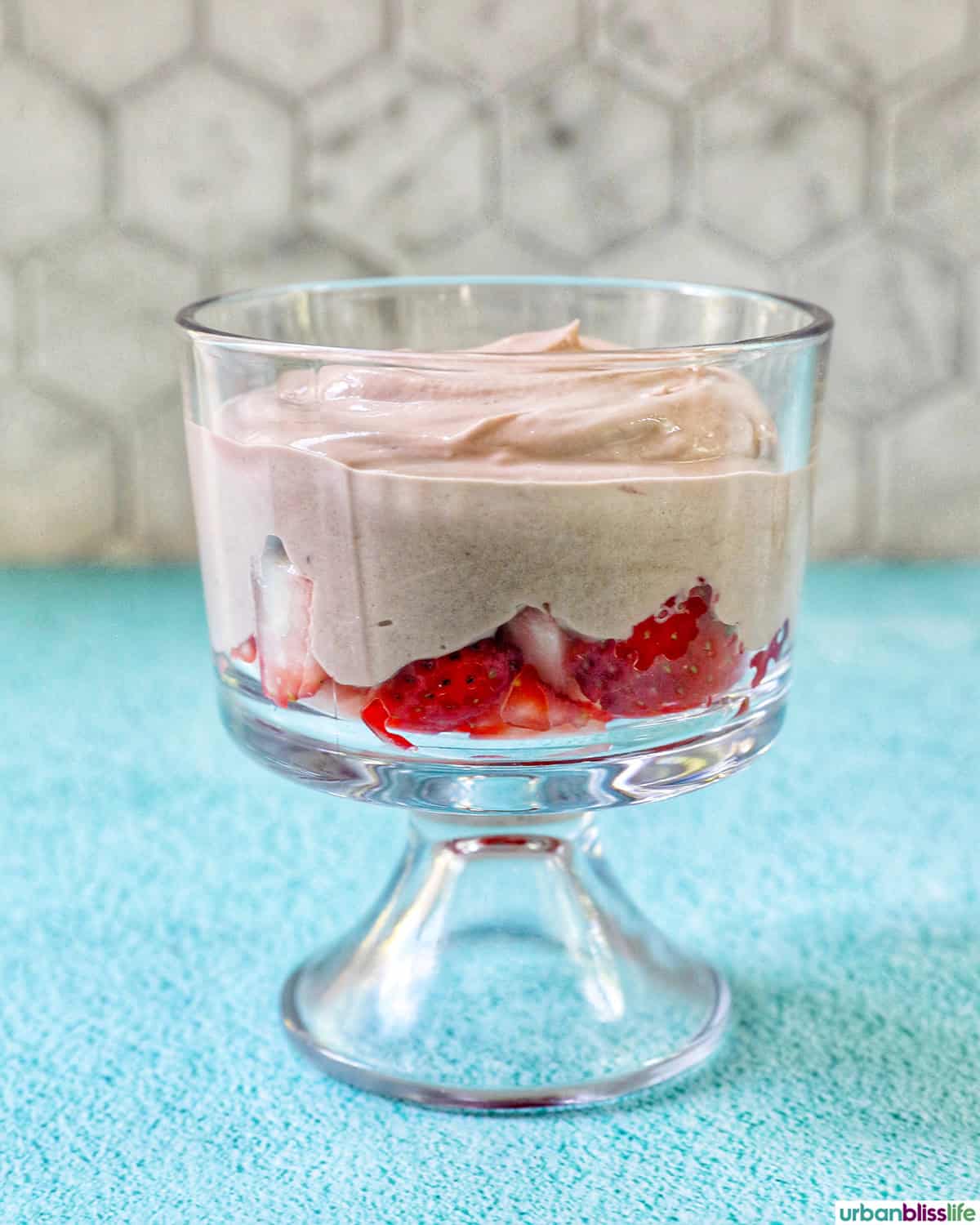 chocolate parfait added to a bowl of strawberries.