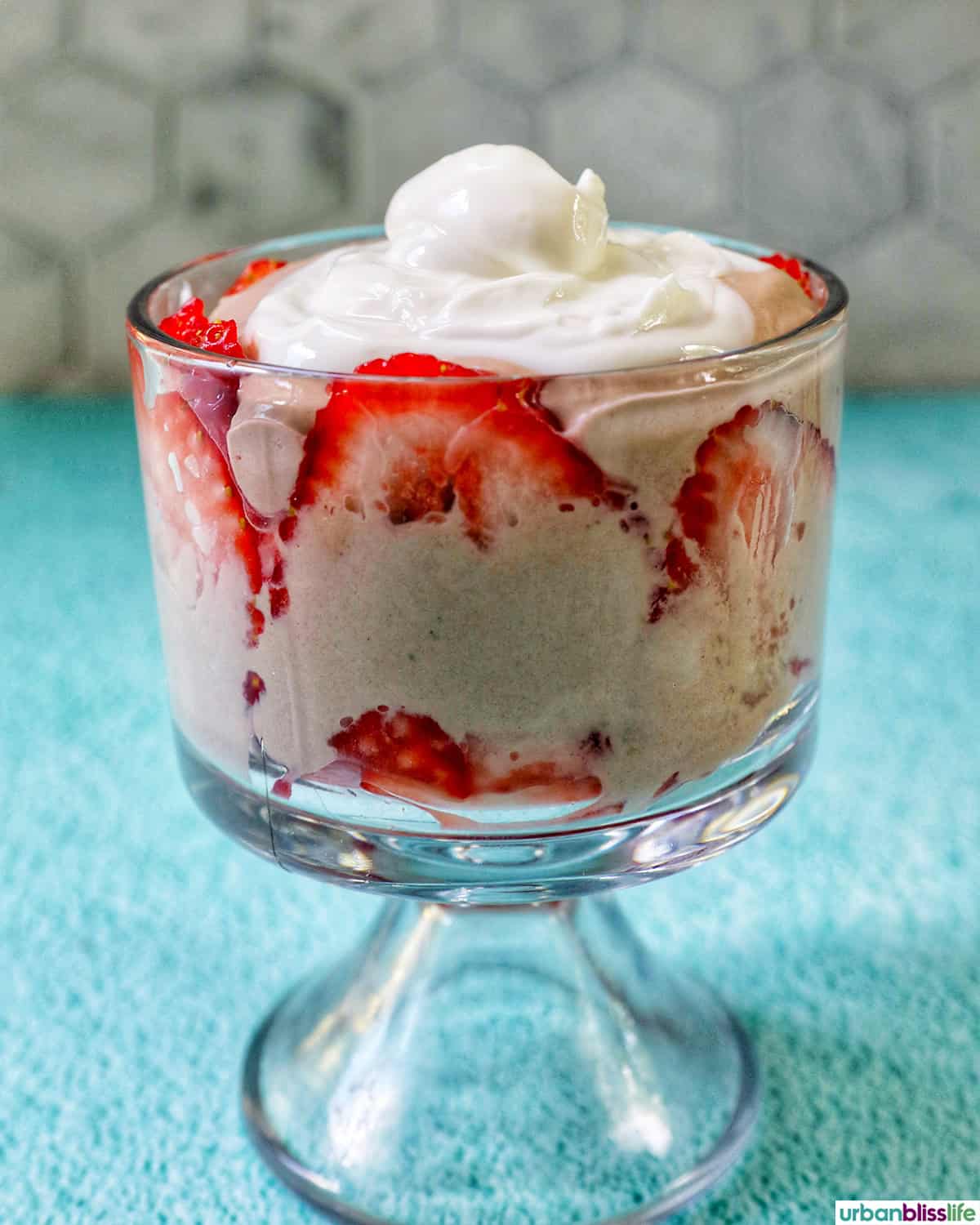 whipped topping, chocolate parfait, strawberries in a glass parfait bowl.
