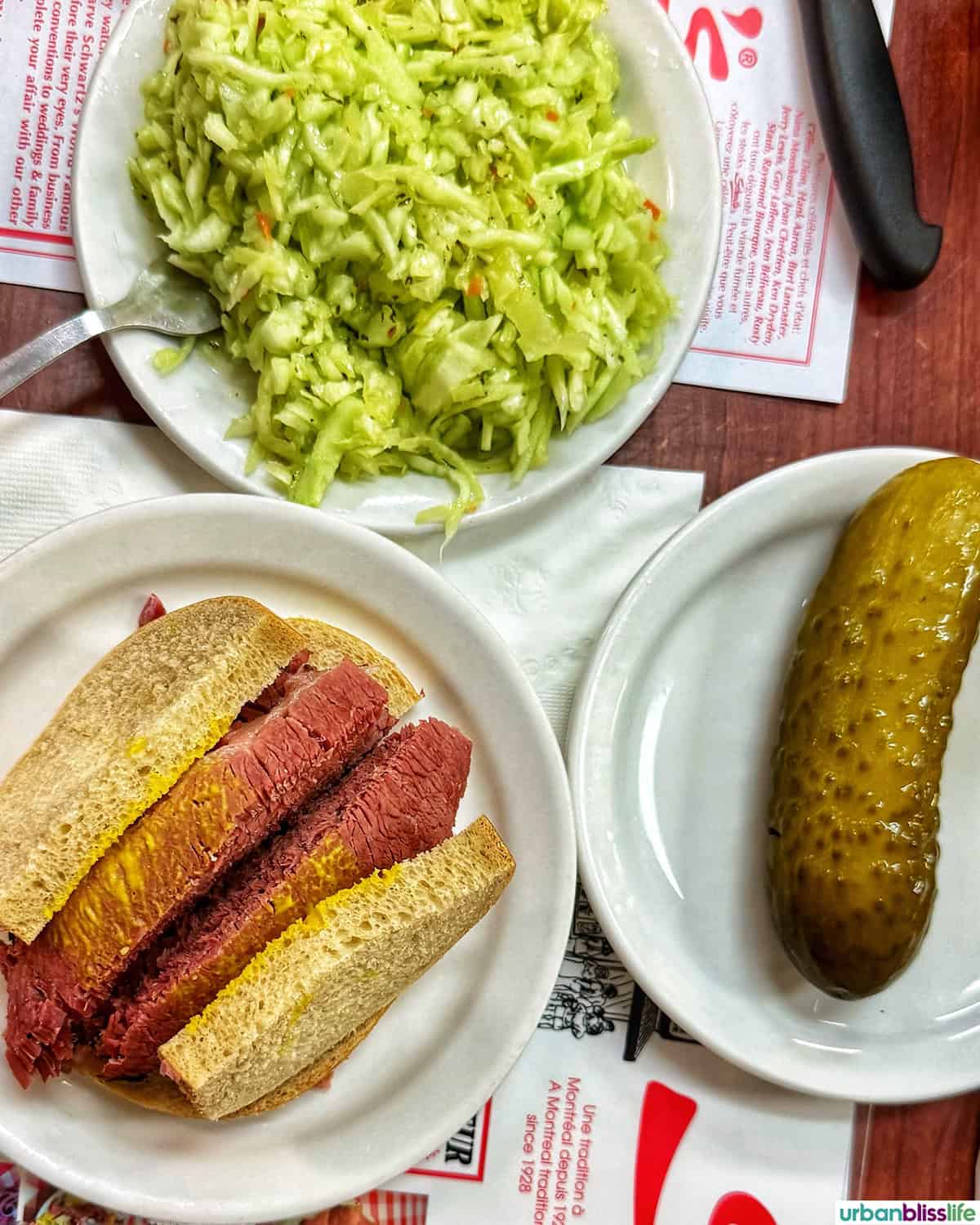 Schwartz's deli smoked meat sandwich, pickles, and coleslaw.