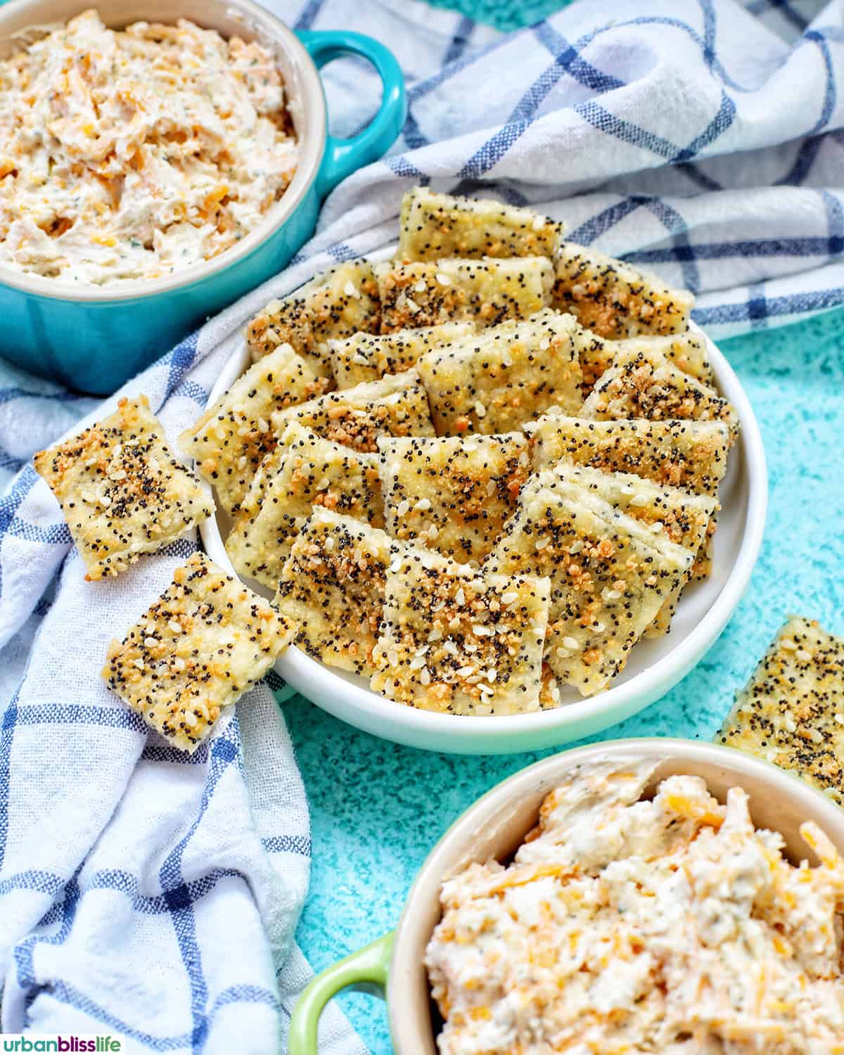 bowl of sesame crackers with bowls of dip.