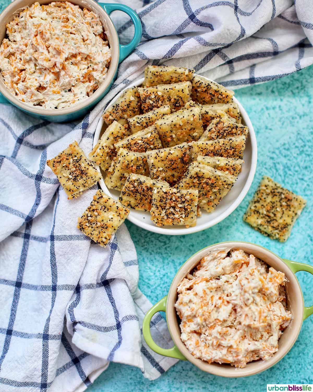 bowl of sesame crackers with bowls of dip.