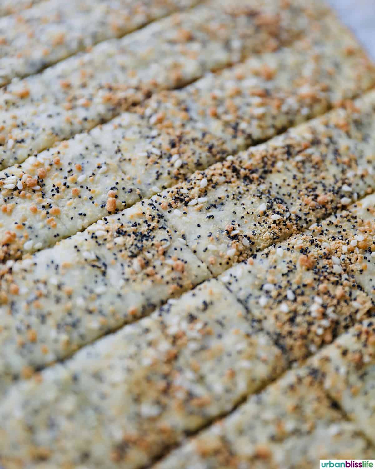 several sesame crackers laid out on a baking sheet.