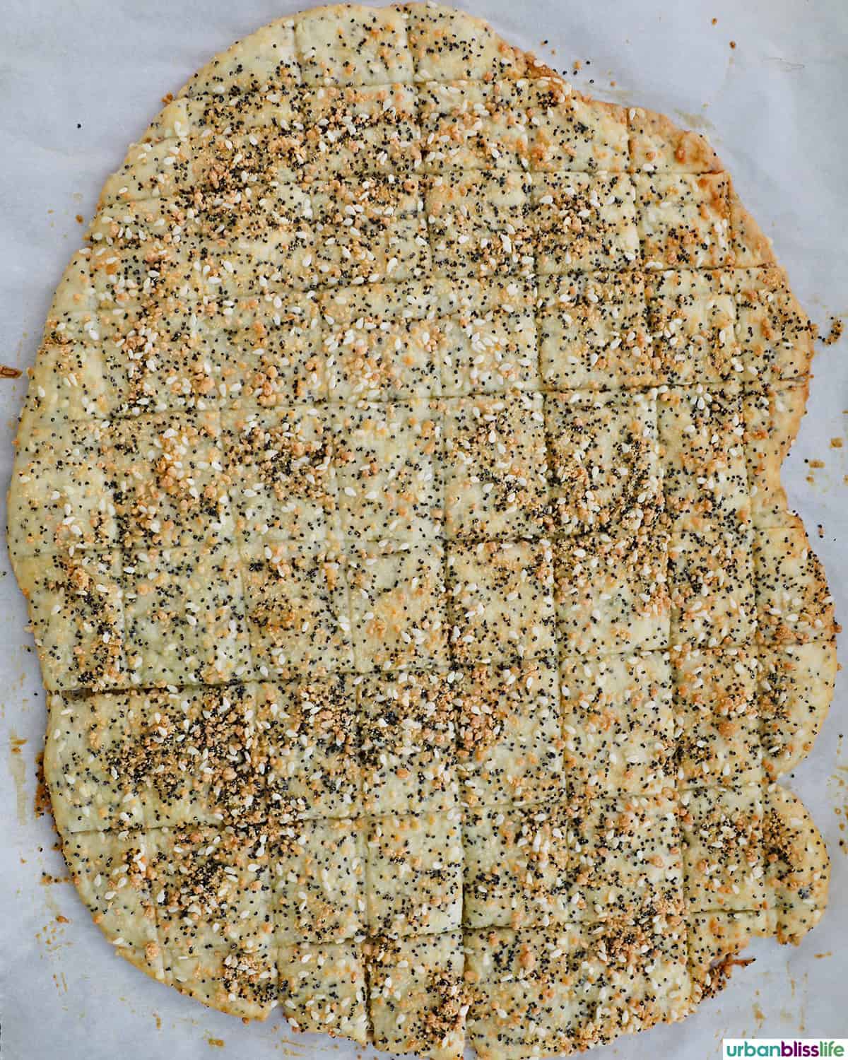 several sesame crackers laid out on a baking sheet.