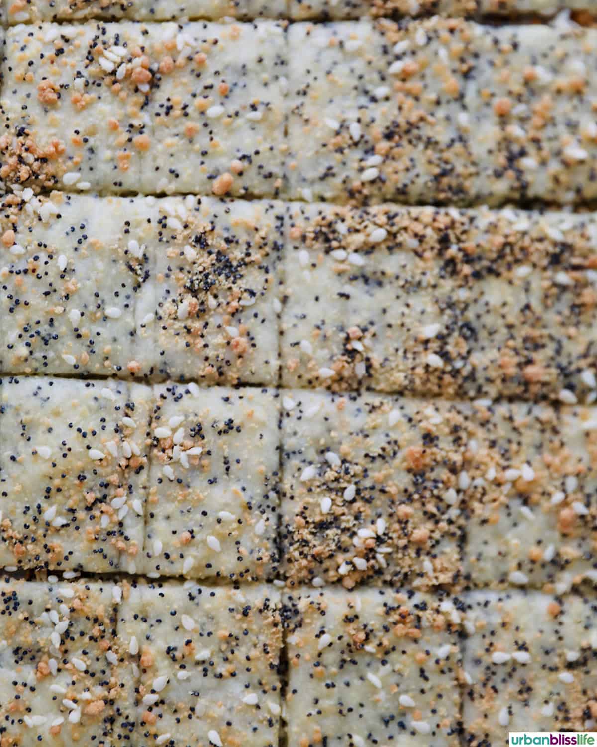 several sesame crackers laid out on a baking sheet.